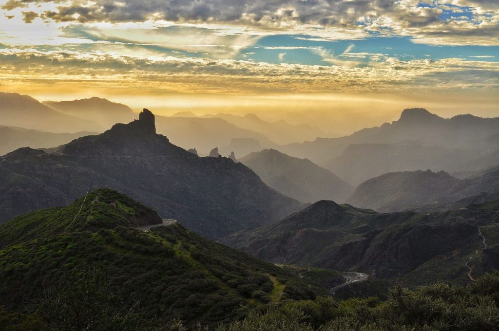 A breathtaking mountain landscape in Gran Canaria at sunset with scenic roads and peaks.